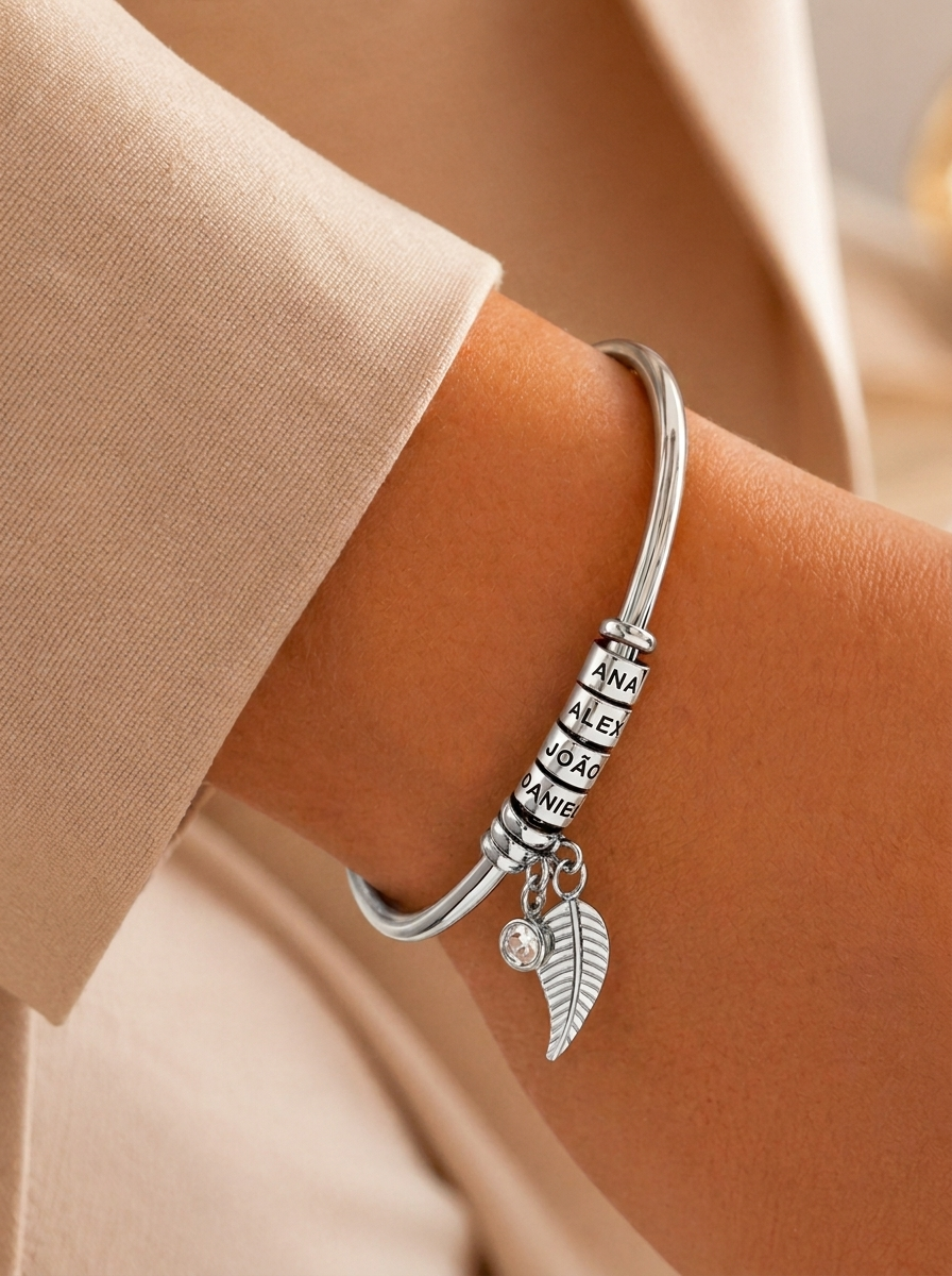Silver family name bracelet with angel wing charm on wrist